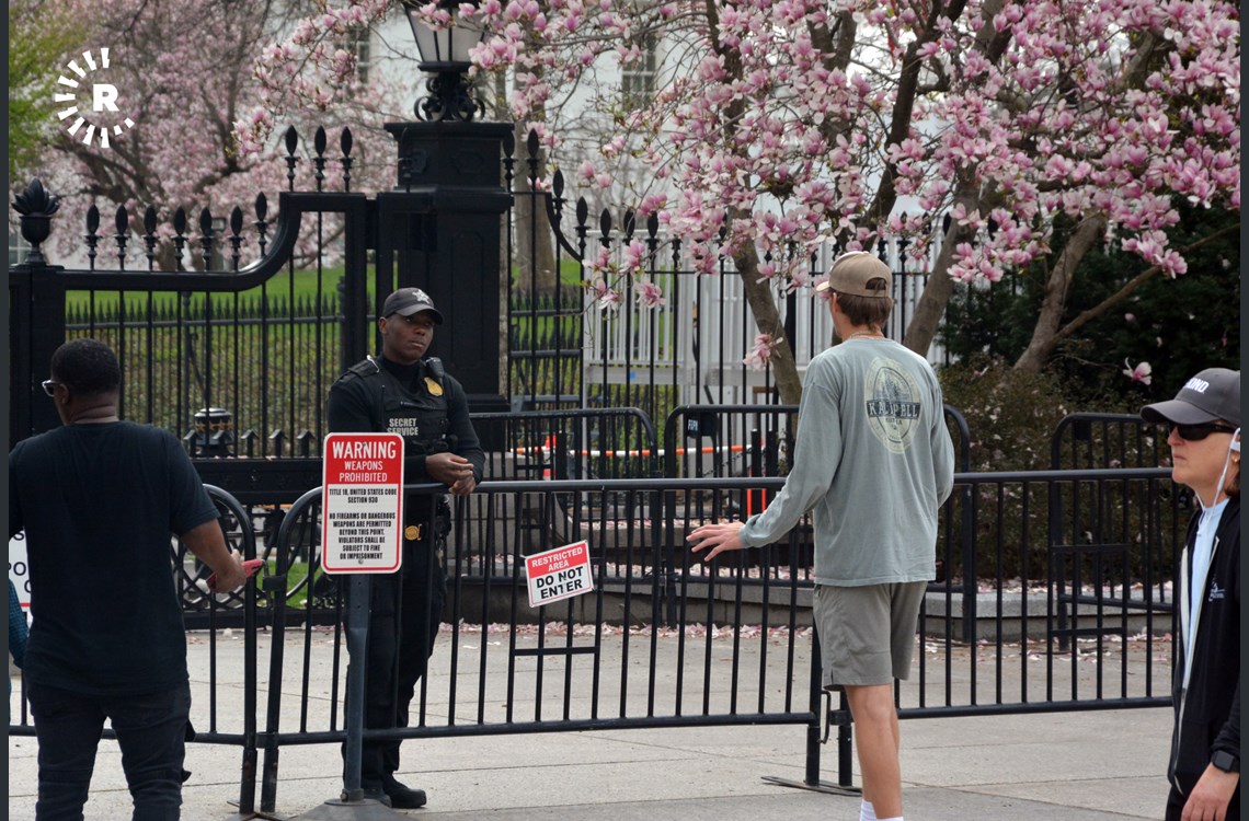 Man speaks with Secret service at the White House gate 